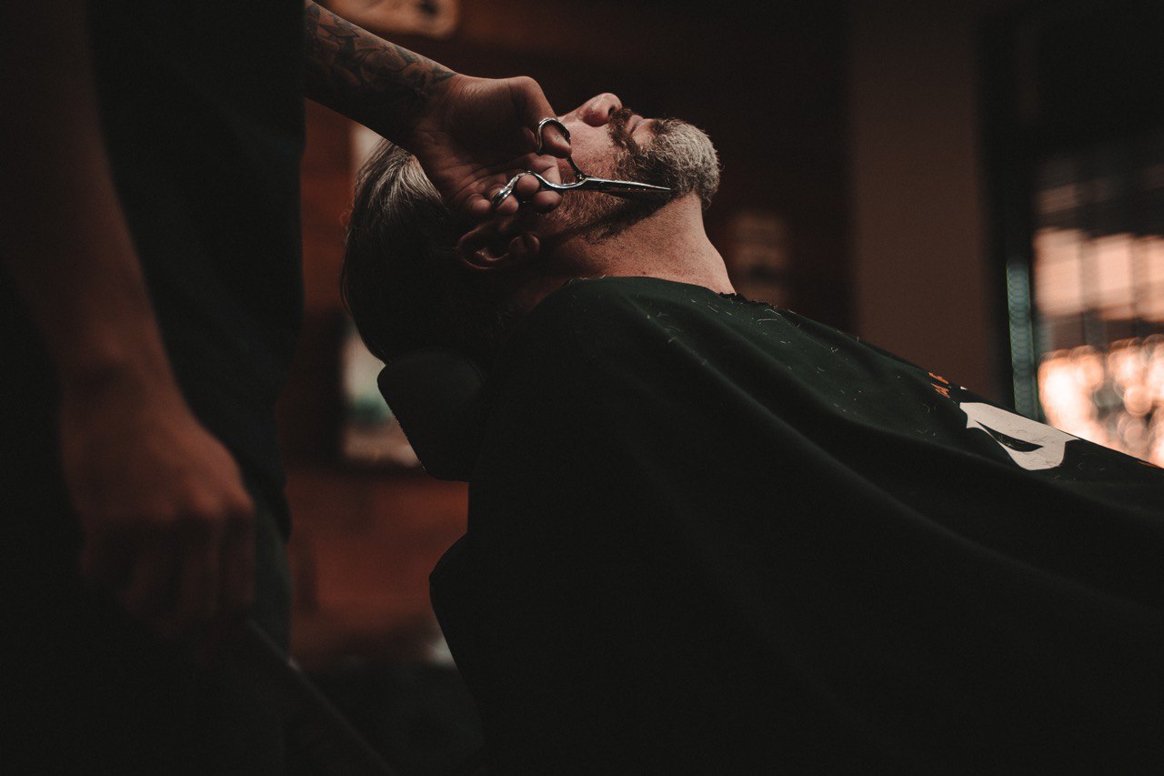homem fazendo a barba de outro homem